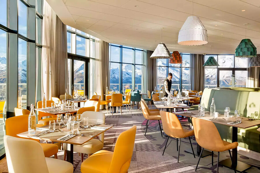 Entouré d'une baie vitrée donnant sur le paysage, accueillant et lumineux le restaurant Le Gourmet (c) Club MED Arcs Panorama