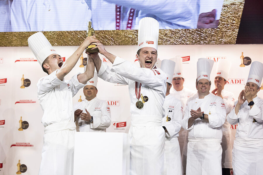 La joie explose élu Cuisinier d'Or 2023 Shaun Rollier et son commis Gabriel Lopez brandissant le trophée (c) Cuisinier d'Or 2023