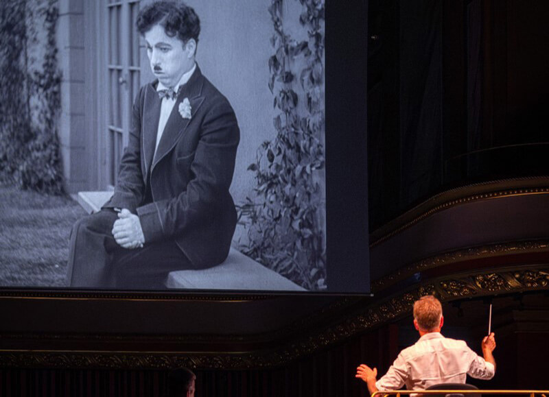 Philippe Béran à la direction de l'OSR jouant la musique composée par Chaplin pour le film ©Eugénie Rousak